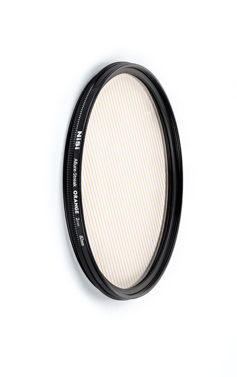 NiSi Allure Streak Orange 67 mm – schräge Ansicht des Kameraeffektfilters mit orangefarbenen Streifen zur Lichtakzentuierung